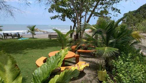 a park with benches and trees and the beach at Hosteria Cumilinche in Same