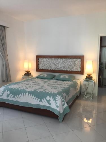 een slaapkamer met een groot bed met 2 lampen bij Yogyakarta Tropicana Villa in Yogyakarta