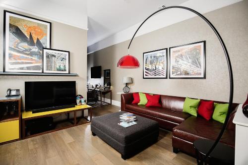a living room with a couch and a flat screen tv at Malmaison Glasgow in Glasgow