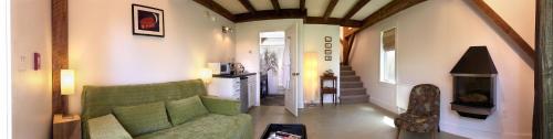 a living room with a green couch and a fireplace at Shoreham Inn Bed & Breakfast in Shoreham