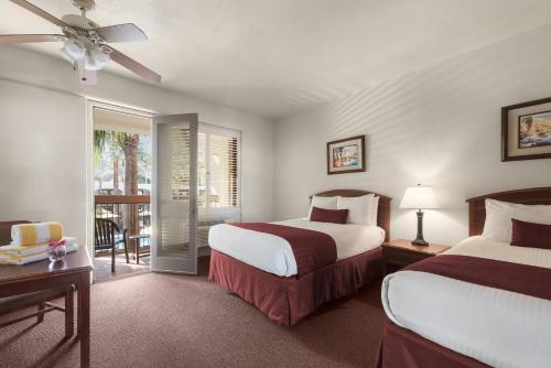 a hotel room with two beds and a balcony at Palm Mountain Resort & Spa in Palm Springs