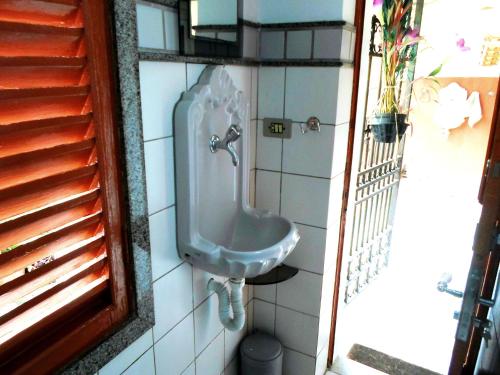 a bathroom with a urinal on a tiled wall at Rio Antigo in Rio de Janeiro