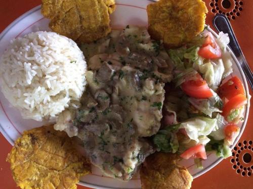 a plate of food with rice and meat and vegetables at Hosteria Cumilinche in Same