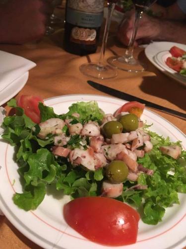 a plate of salad with shrimp and greens on a table at Hosteria Cumilinche in Same