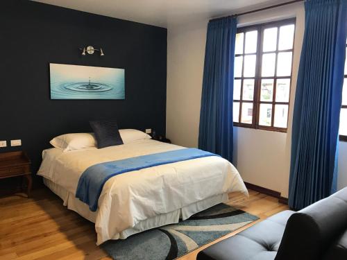 1 dormitorio con 1 cama con cortinas azules en Hotel Casa Ecuatreasures Centro Historico en Quito