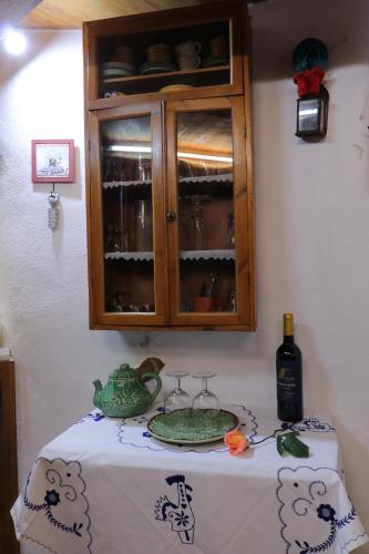 a table with a cabinet with glasses and a plate on it at Moinho das Carrascas in Caldas da Rainha