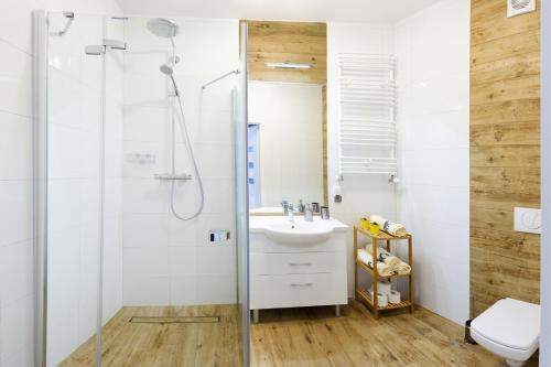 y baño con ducha y lavamanos. en Apartament Solna 11C Kołobrzeg en Kołobrzeg