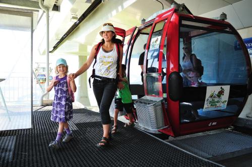 a woman and two children are getting on a bus at Hotel Kraftquelle Schlossblick in Angerberg