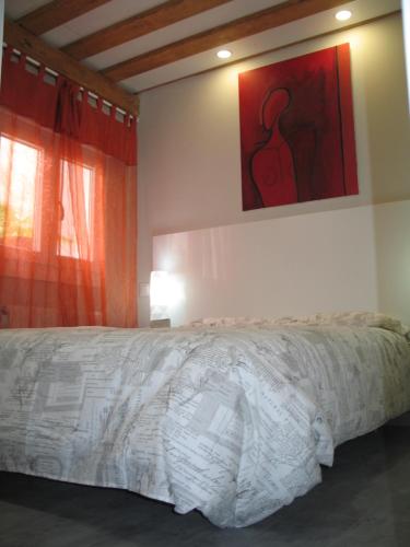 a bedroom with a bed and a painting on the wall at Apartamento Portales in Logroño