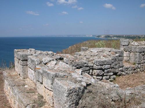 an old stone wall with the ocean in the background at Guest House Orbita in Tyulenovo