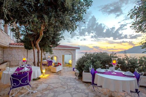 a patio with two tables and chairs with a view of the ocean at Lukka Exclusive Hotel – Adult Only +12 in Kaş