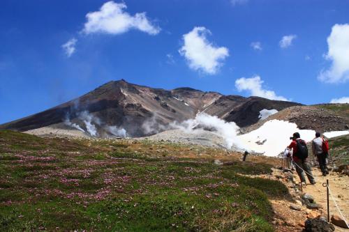a group of people walking up a mountain at Higashikawa Asahidake Onsen Hotel Bear Monte in Higashikawa