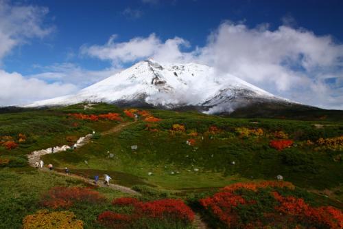 a snow covered mountain on top of a hill at Higashikawa Asahidake Onsen Hotel Bear Monte in Higashikawa