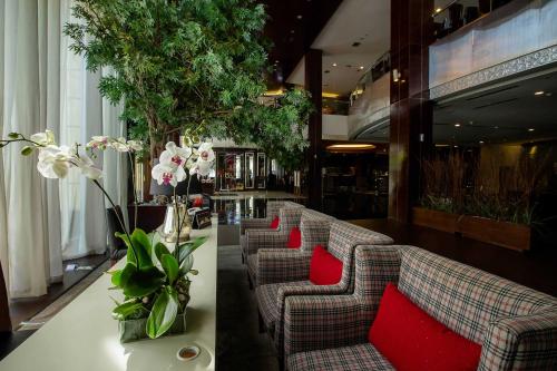 a row of couches with red pillows in a lobby at The Arista Hotel Palembang in Palembang