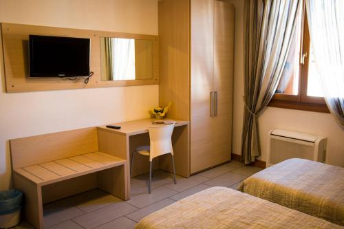 a hotel room with a desk and a bed at Hotel Ristorante Cigno in Latisana