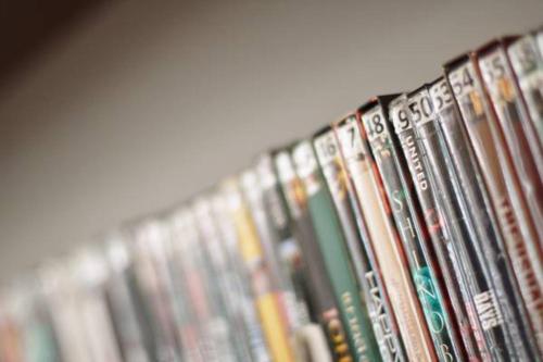 a row of dvds are lined up on a shelf at Asoke Residence Sukhumvit by UHG in Bangkok