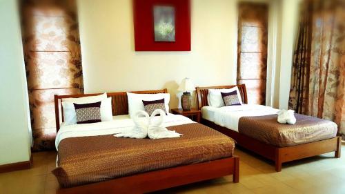 ein Hotelzimmer mit zwei Betten mit Handtüchern darauf in der Unterkunft Thongsathit Hill Resort Khao Yai in Nong Nam Daeng