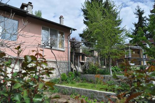 a pink house with a garden in front of it at Holiday Home Vilata in Kŭrdzhali