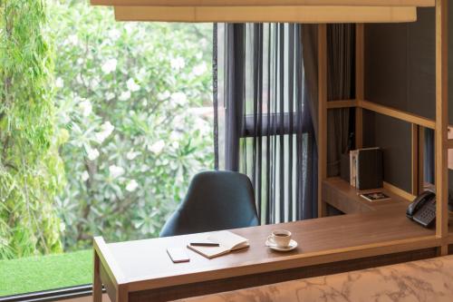 an office with a desk and a chair and a window at Volve Hotel Bangkok in Bangkok