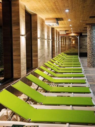 a row of green lounge chairs in a room at Hot Springs Medical and SPA in Banya