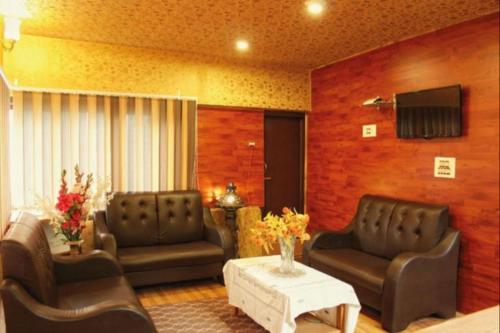 a living room with two leather chairs and a table at Walisons Peace Resort in Pahalgām