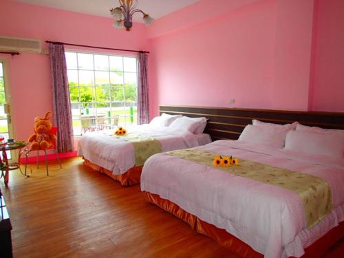 two beds in a pink room with pumpkins on them at Flower Tamura in Guanshan