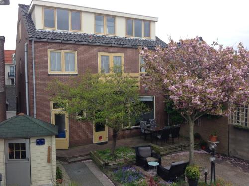 an aerial view of a brick house with a tree at Pension de Zeeschelp in Domburg