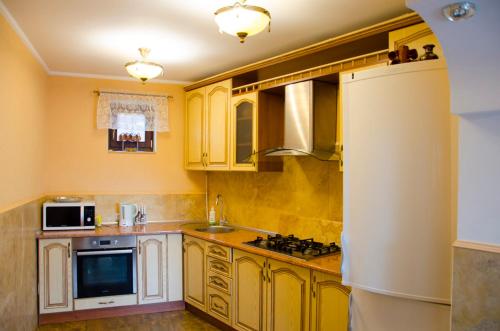 a kitchen with yellow cabinets and a stove top oven at Liubava in Polyana