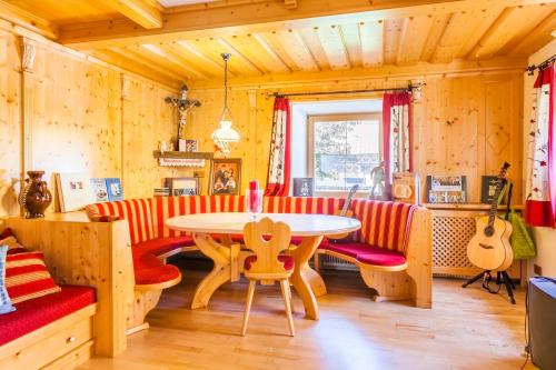 a living room with a table and red and white chairs at Grillhof-Gut in Mauterndorf