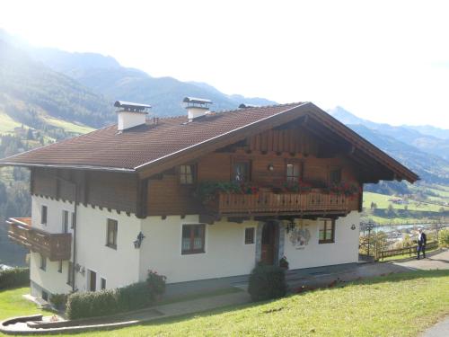 una casa en una colina con montañas al fondo en Appartement Kirchner, en Kleinsonnberg