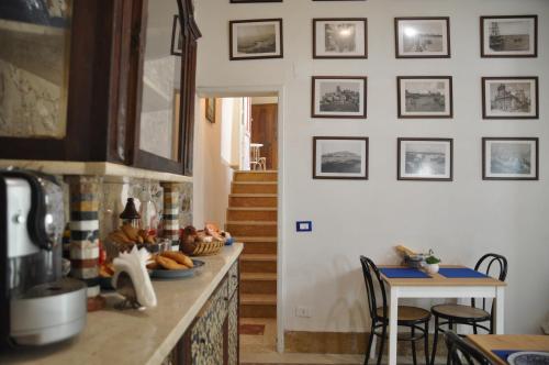 uma cozinha com um balcão com uma mesa e algumas imagens na parede em Case Bruno Residenze Tipiche em Erice