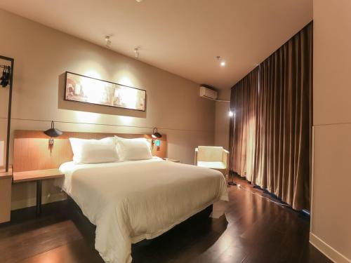 海口市にあるJinjiang Inn Haikou Guomao Jinlong Roadの大きなベッドと窓が備わるホテルルームです。