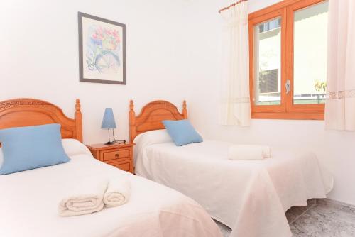 een slaapkamer met 2 bedden en een raam bij Pinya in Port d'Alcudia