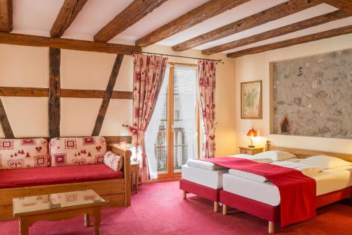 a bedroom with two beds and a window at Hostellerie Schwendi in Kientzheim