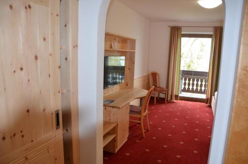 a room with a desk and a chair and a window at Gasthof-Pension Urzn in Altmünster