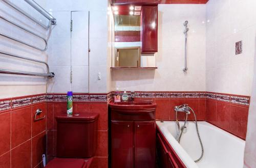 モスクワにあるAppartment Nametkina 1の赤いバスルーム(シンク、バスタブ付)