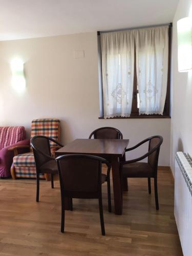 comedor con mesa, sillas y sofá en Apartaments Alt Aneu Baqueira, en Isavarre