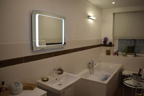 a bathroom with a sink and a tub and a mirror at Pension Lachmann in Pfaffendorf