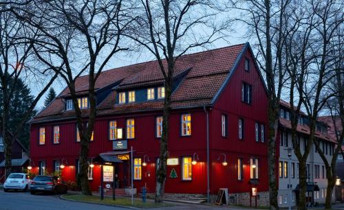 a large red house with lights on at Hotel Zum Harzer in Clausthal-Zellerfeld
