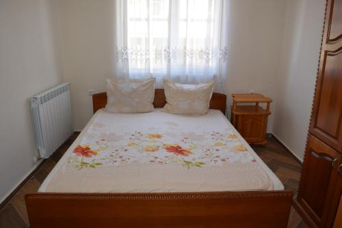 a bedroom with a bed with a floral bedspread at Grande Apartment in Tsarevo
