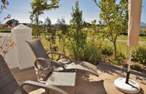 a couple of chairs and a lamp on a patio at Wild Mushroom Country House in Stellenbosch