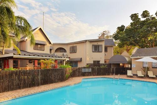 a swimming pool in front of a house at First Group Lake View Cabanas in St Lucia