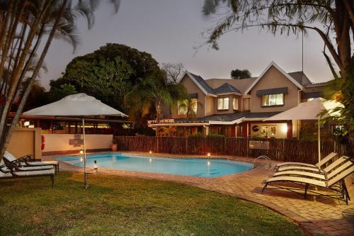 a house with a swimming pool in front of a house at First Group Lake View Cabanas in St Lucia