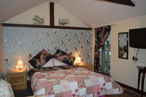 a bedroom with a bed and two lamps and a tv at Forty Winks In North Norfolk in Thorpe Market