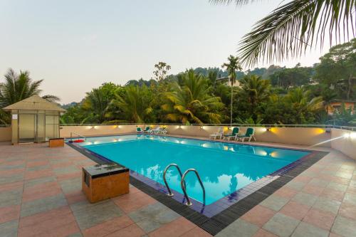 
a swimming pool with a pool table and chairs at Devon Hotel in Kandy
