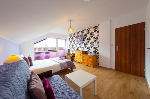 a bedroom with a bed and a couch and a window at Willa Zacisze in Ustroń