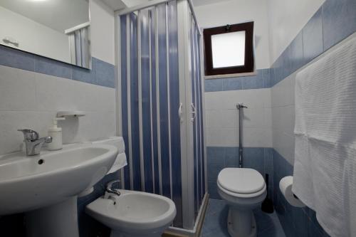 La salle de bains est pourvue d'un lavabo, de toilettes et d'une douche. dans l'établissement Casa Madonna delle Grazie, à Modica