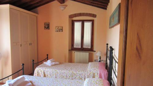 a bedroom with two beds and a window at Chiardiluna in Pistoia