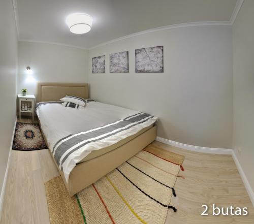 a bedroom with a large bed in a room at Six Apartment Simona in Vilnius