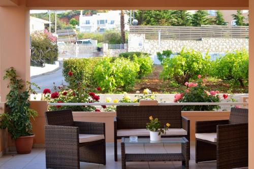 a patio with chairs and tables and a garden at Sofoklis Apts in Stalos